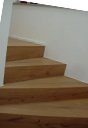 Gerade Treppe mit Holzstufen und weißen Wangen